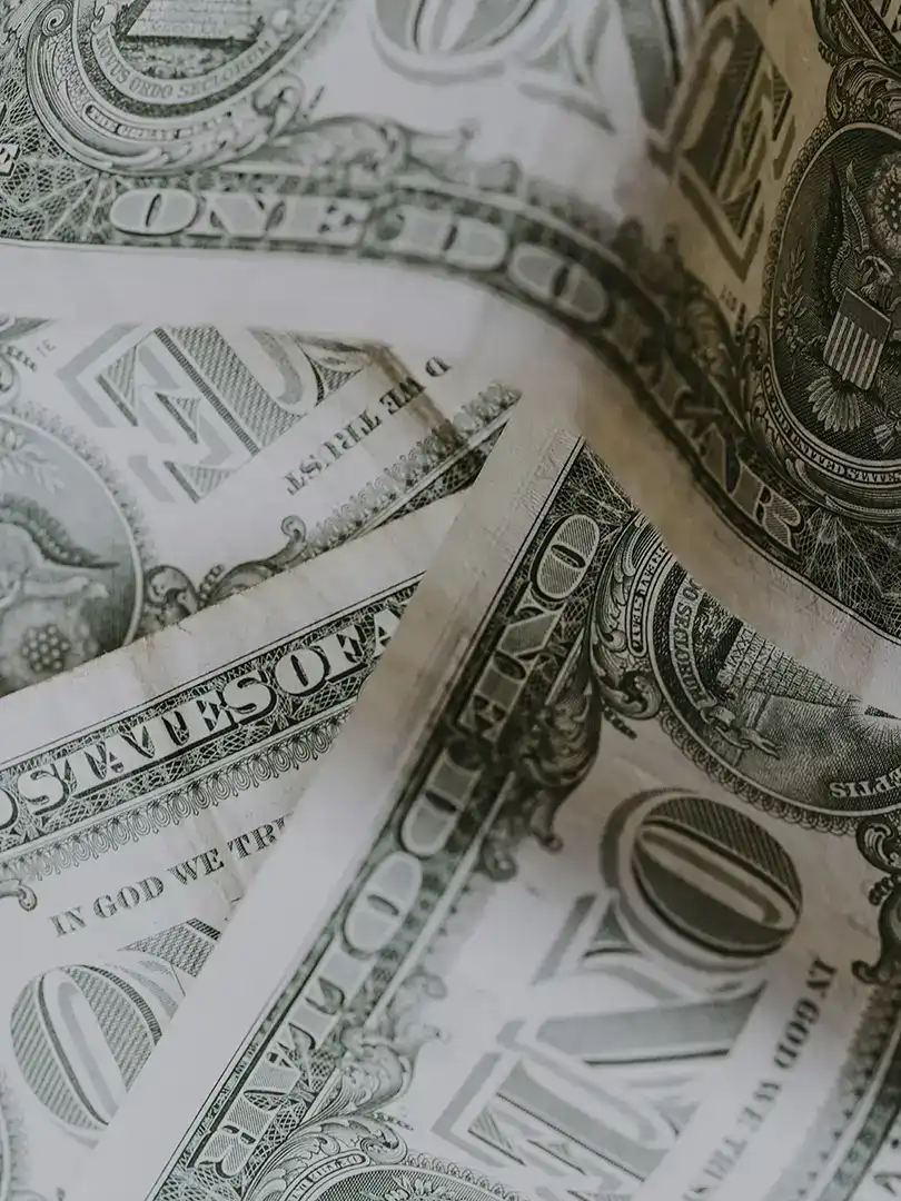 Close-up of US dollar bills emphasizing crime prevention funding in San Antonio.
