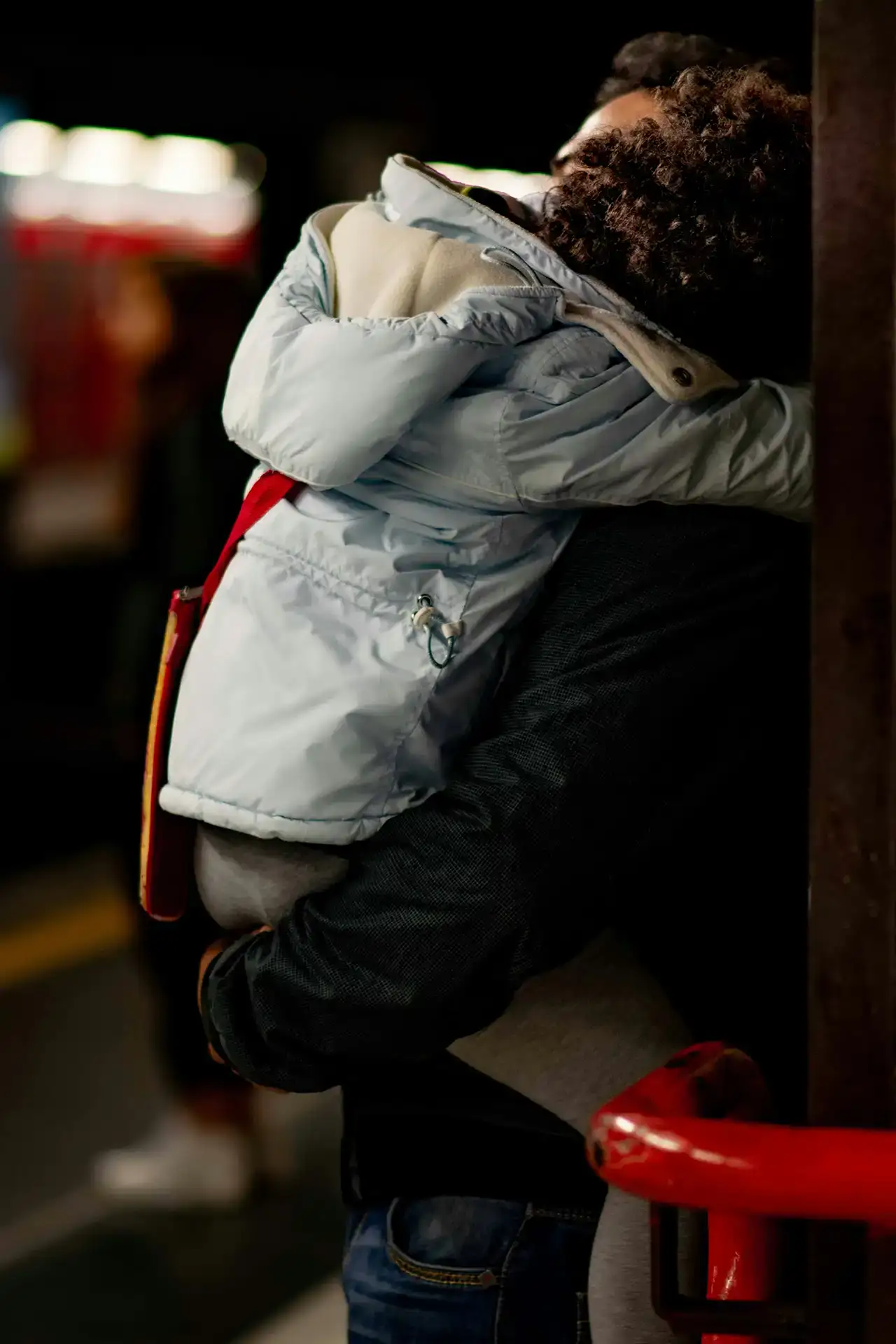 Young person hugging an adult at a San Antonio transit station, promoting community safety.