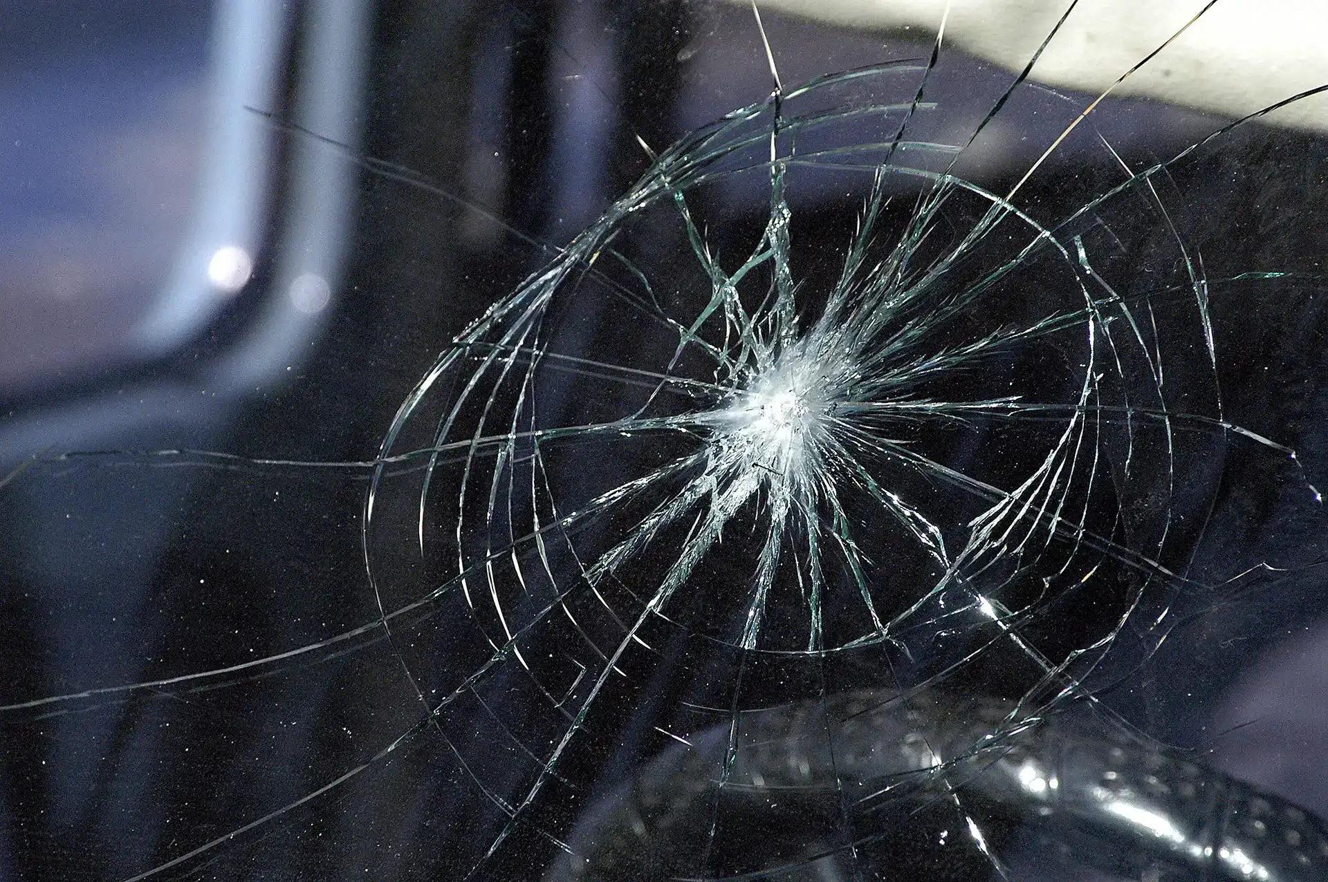 Cracked windshield with shattered glass in San Antonio crime scene investigation.