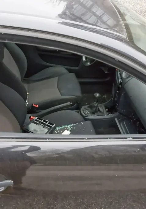 Damaged car window with shattered glass in San Antonio crime scene.
