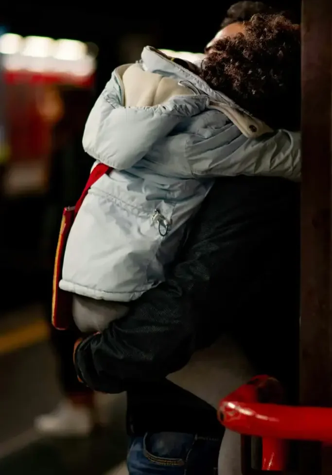 Young person hugging an adult at a San Antonio transit station, promoting community safety.