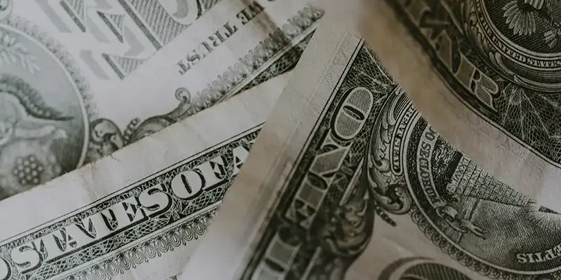 Close-up of US dollar bills emphasizing crime prevention funding in San Antonio.